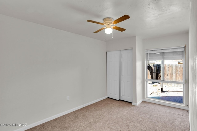 unfurnished bedroom with light carpet, a closet, and ceiling fan