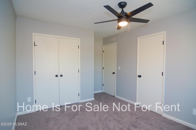 unfurnished bedroom featuring ceiling fan, light colored carpet, and a closet