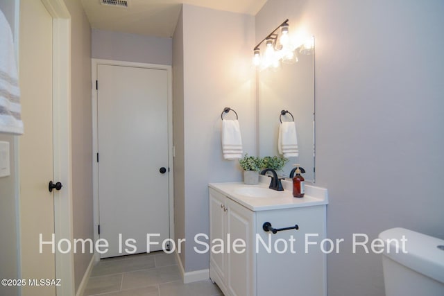 bathroom with tile patterned flooring, vanity, and toilet