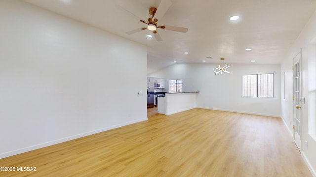 unfurnished living room with ceiling fan, light wood-type flooring, and vaulted ceiling