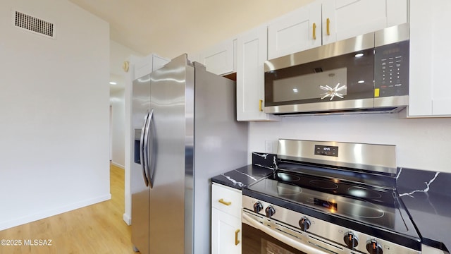 kitchen with white cabinetry, light hardwood / wood-style flooring, and appliances with stainless steel finishes