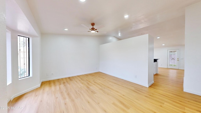 empty room featuring ceiling fan, light hardwood / wood-style floors, and vaulted ceiling