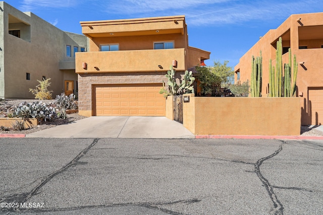 pueblo-style house featuring a balcony and a garage