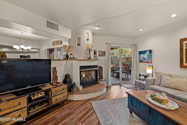 living room with dark wood-type flooring and an inviting chandelier