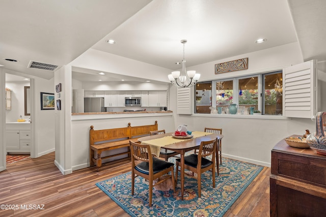 dining space with an inviting chandelier and hardwood / wood-style floors