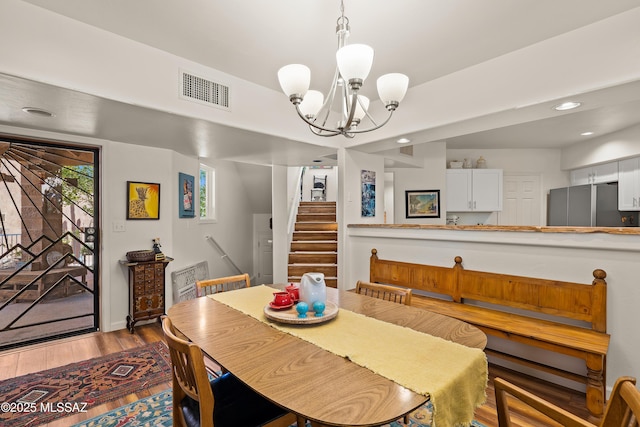 dining area with hardwood / wood-style floors and a notable chandelier