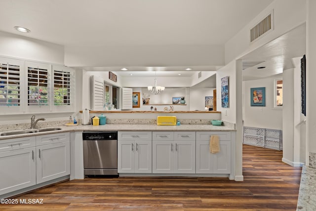 kitchen with dark hardwood / wood-style floors, pendant lighting, dishwasher, sink, and white cabinets