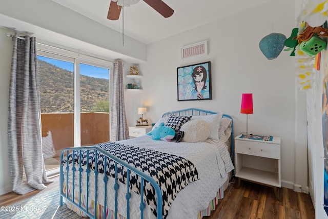 bedroom with access to exterior, dark wood-type flooring, a mountain view, and ceiling fan