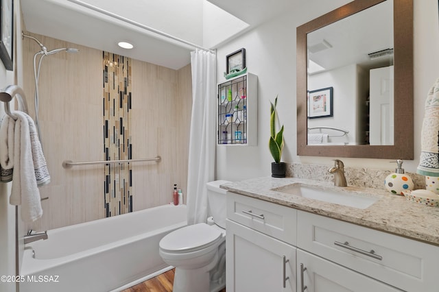 full bathroom featuring a skylight, hardwood / wood-style flooring, vanity, toilet, and shower / bathtub combination with curtain