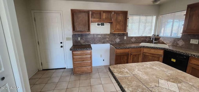 kitchen featuring light tile patterned floors, dishwasher, backsplash, and sink