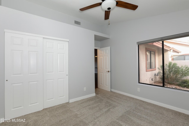 unfurnished bedroom with ceiling fan, a closet, and light colored carpet