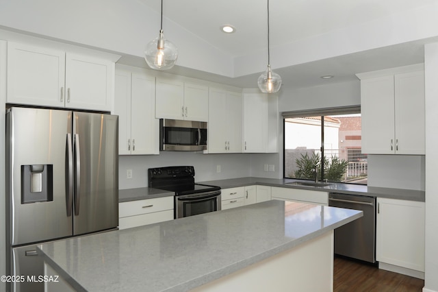 kitchen with sink, dark stone countertops, appliances with stainless steel finishes, decorative light fixtures, and white cabinetry