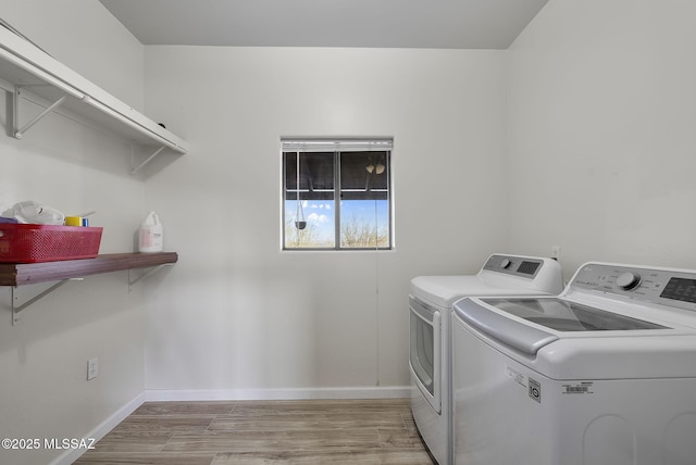 clothes washing area featuring light wood-type flooring and separate washer and dryer