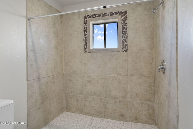 bathroom featuring toilet and tiled shower