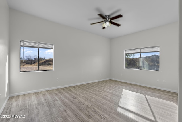 empty room with baseboards, light wood-style floors, and a ceiling fan