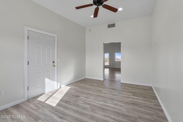 empty room with ceiling fan and light hardwood / wood-style floors