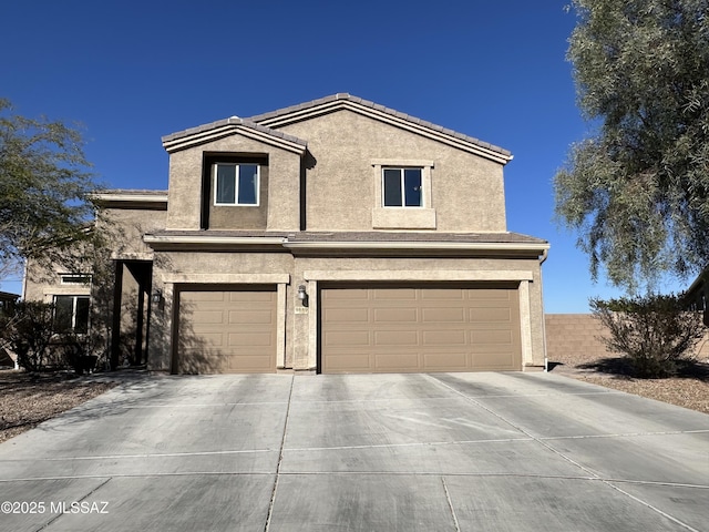 traditional-style home with concrete driveway, an attached garage, a tiled roof, and stucco siding