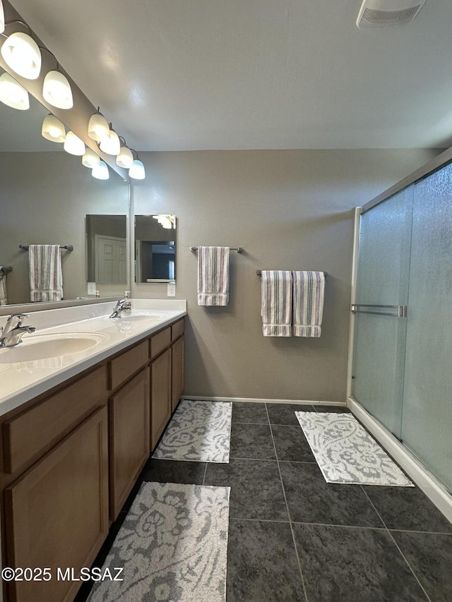 full bathroom with double vanity, a sink, visible vents, and a shower stall