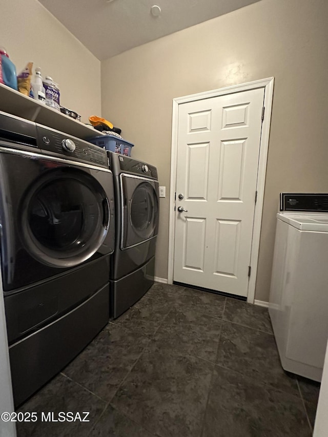 laundry room with laundry area, baseboards, and washing machine and clothes dryer