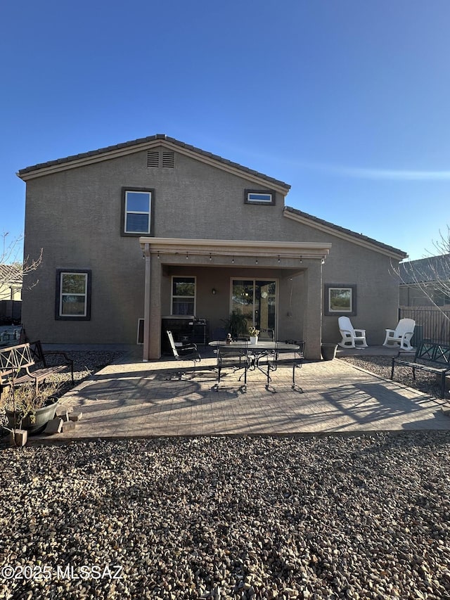 rear view of property with a patio and stucco siding