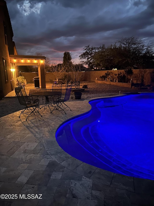 view of swimming pool with a patio area, a fenced backyard, outdoor dining area, and a fenced in pool