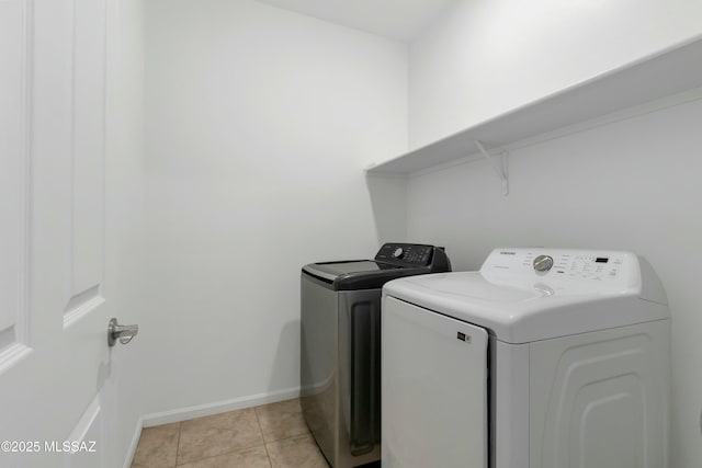 clothes washing area with light tile patterned floors and separate washer and dryer