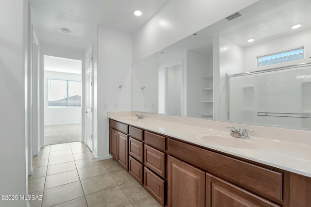 bathroom featuring a shower with door, tile patterned floors, and vanity