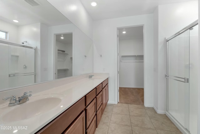 bathroom featuring a shower with door, vanity, and tile patterned flooring