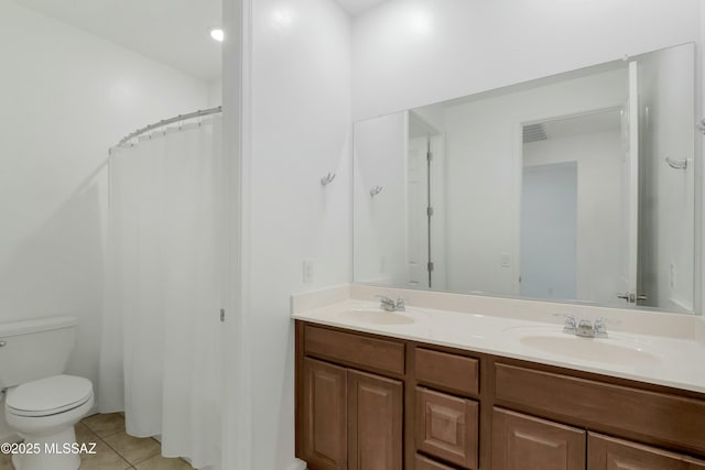 bathroom featuring a shower with shower curtain, vanity, tile patterned floors, and toilet