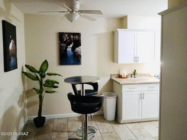 bar featuring ceiling fan and white cabinetry