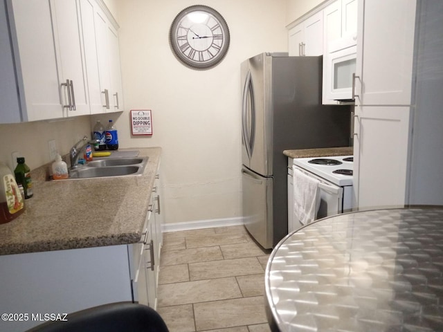 kitchen with white cabinets, sink, white appliances, and stone counters