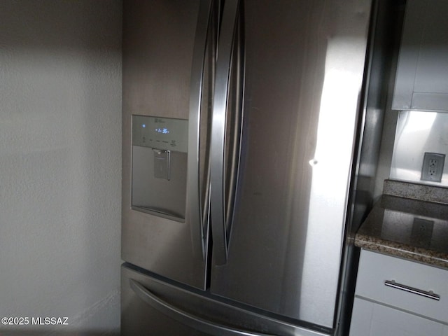 details with stainless steel refrigerator with ice dispenser and dark stone counters