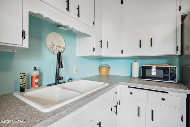 kitchen featuring sink and white cabinets