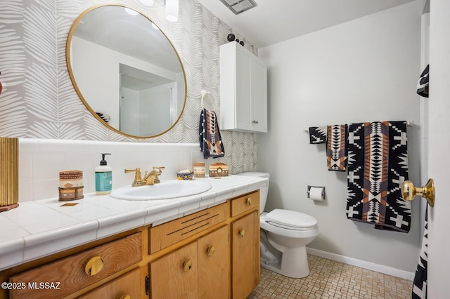 bathroom with tile patterned floors, tasteful backsplash, vanity, and toilet