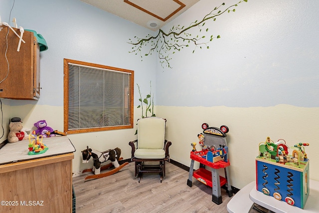 rec room featuring light hardwood / wood-style flooring and lofted ceiling