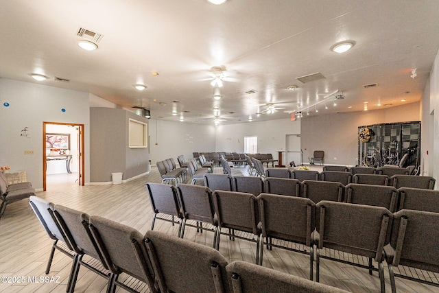 cinema featuring light wood-type flooring and ceiling fan