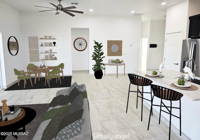 dining space with ceiling fan and sink