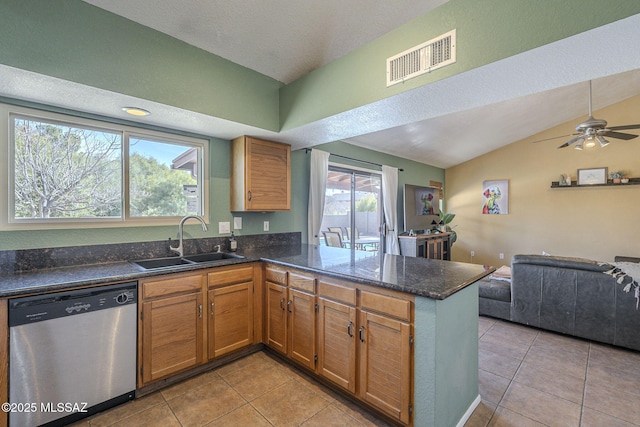 kitchen featuring vaulted ceiling, stainless steel dishwasher, kitchen peninsula, and sink