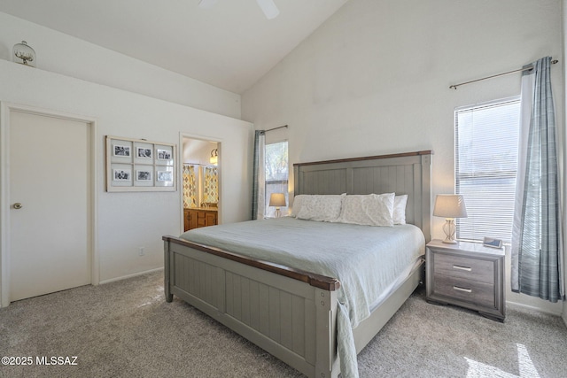 bedroom featuring light colored carpet, ensuite bath, high vaulted ceiling, and multiple windows