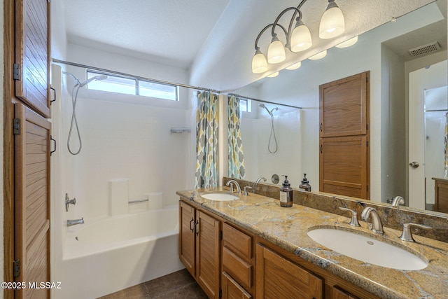 bathroom featuring tile patterned flooring, shower / bath combo, vanity, and a textured ceiling