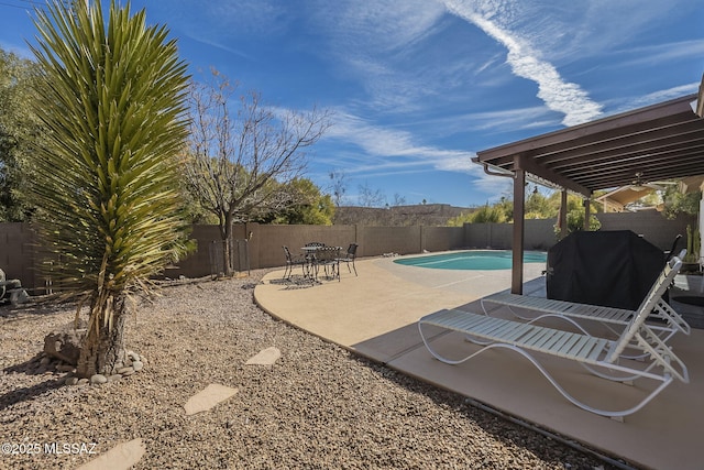 view of patio / terrace with a fenced in pool and a grill