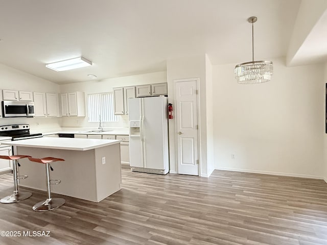 kitchen with electric range, white fridge with ice dispenser, a center island, an inviting chandelier, and pendant lighting