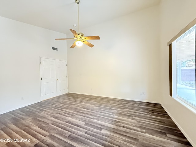 empty room with hardwood / wood-style flooring, high vaulted ceiling, and ceiling fan