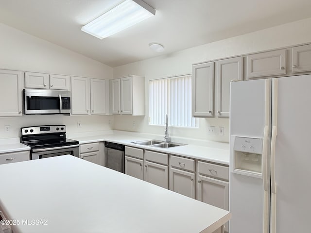 kitchen featuring appliances with stainless steel finishes, lofted ceiling, and sink