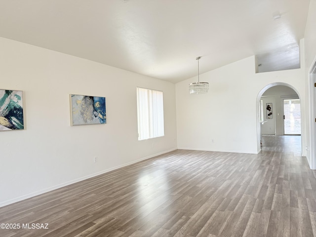 unfurnished room featuring a chandelier, a healthy amount of sunlight, and wood-type flooring