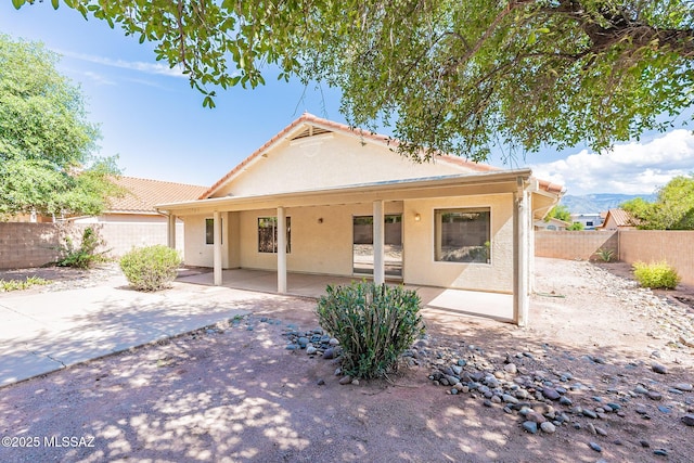 rear view of property with a mountain view and a patio