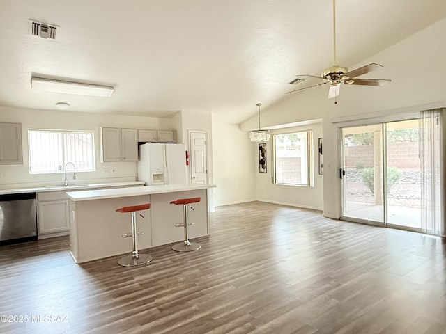 kitchen featuring pendant lighting, dishwasher, a center island, white refrigerator with ice dispenser, and lofted ceiling