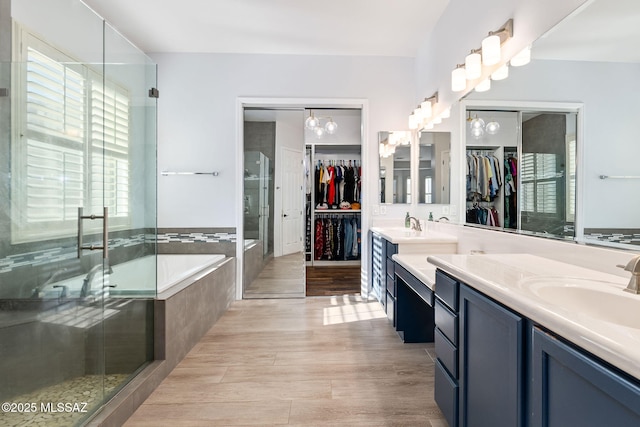 bathroom with hardwood / wood-style floors, shower with separate bathtub, and vanity