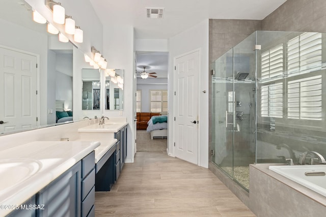 bathroom with wood-type flooring, separate shower and tub, ceiling fan, and vanity