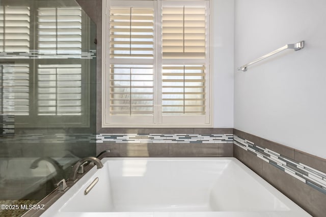 bathroom with plenty of natural light and a tub to relax in